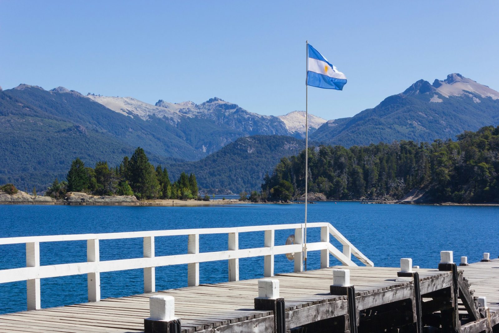 Foto em Bariloche. deck de madeira com bandeira branca e azul com sol amarelo no meio