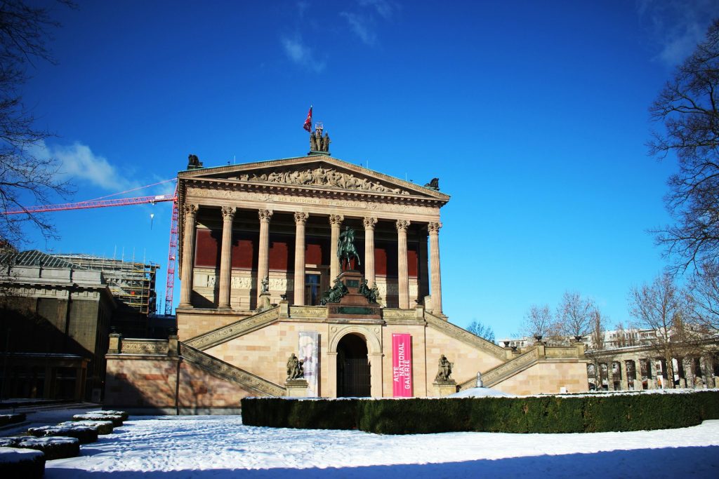 Alte Nationalgalerie. Edificio grande de concreto com escadarias laterais e esculturas no encontro das escadarias. 