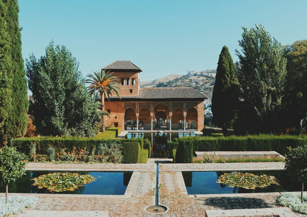 Palacio Nasridas. Foto de edifício marrom com piscinas na frente