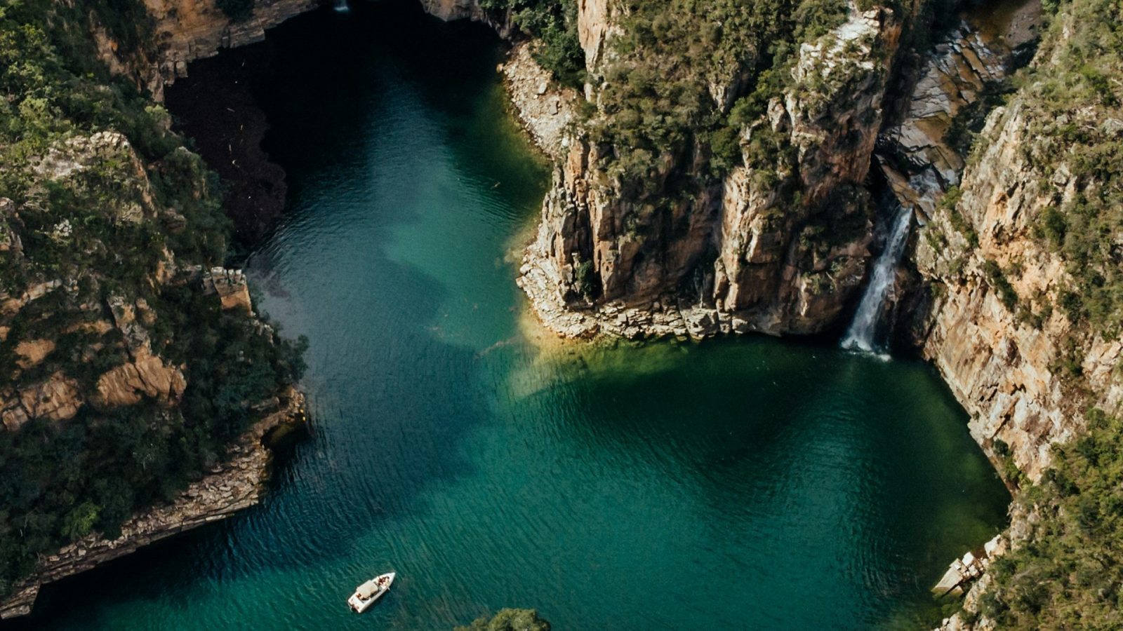 Capitolio. Corpo de agua entre as montanhas com barco atracado