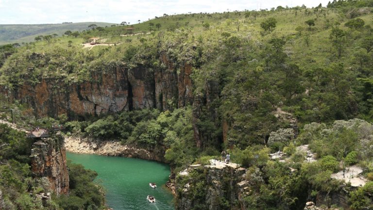 Capitolio. Corpo de agua entre montanhas rochosas com pessoas remando.