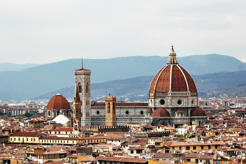 Florença. Foto de cima de uma cidade e edificio com grande cupula durante o dia.