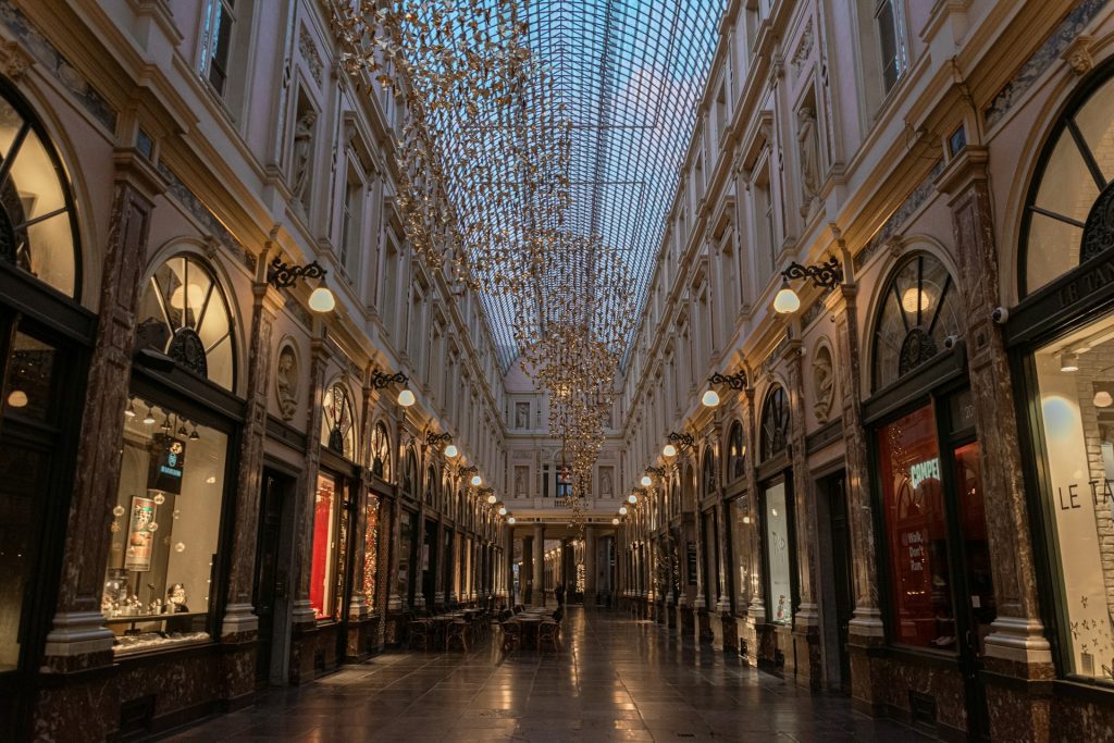 Galeria bruxelas. Foto de uma galeria fechada com lustres redondos pendurados no teto.