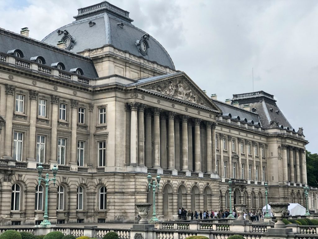 Palacio real burxelas. Foto de um edificio de concreto cinza com muita janelas e colunas na frente