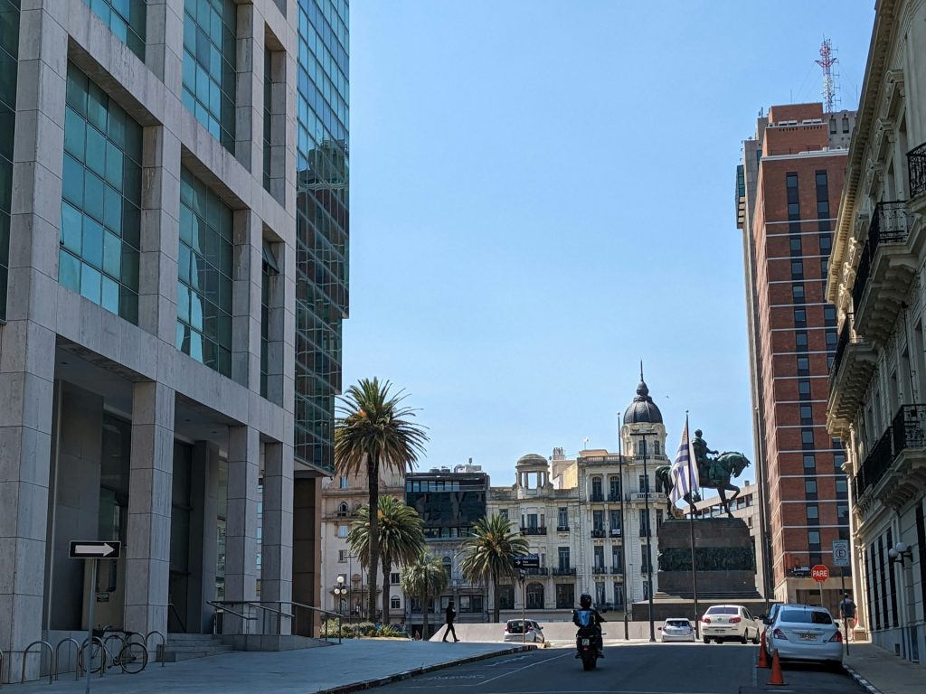 Montevideu. foto de uma rua com uma praça no final com estatua cinza e edificios ao redor