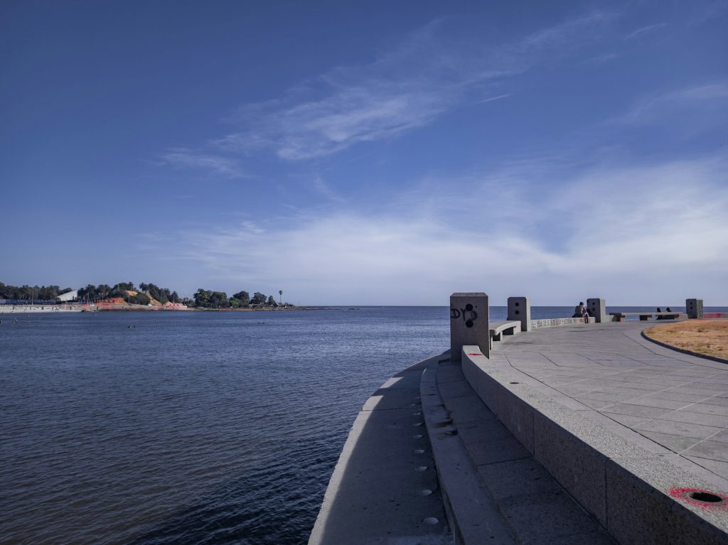 Rambla de Montevidéu. foto de um caminho de concreto ao lado de um corpo de agua.