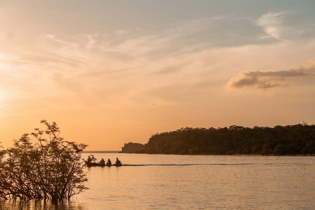 Alter do chão. Foto de corpo de agua com pequeno barco navegando ao entardecer.