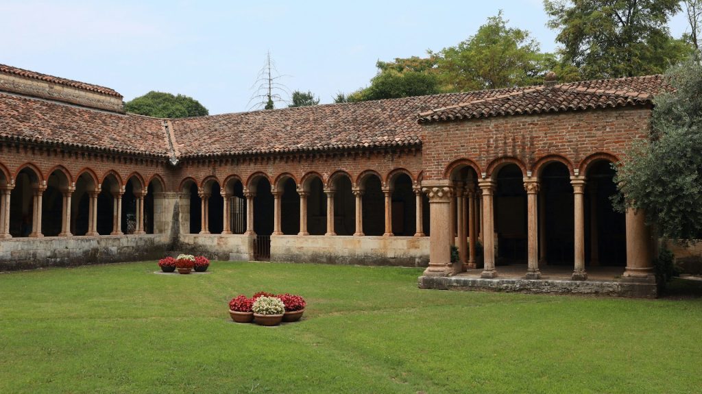 Verona. Patio com grande gramado cercado de construção de arcos.