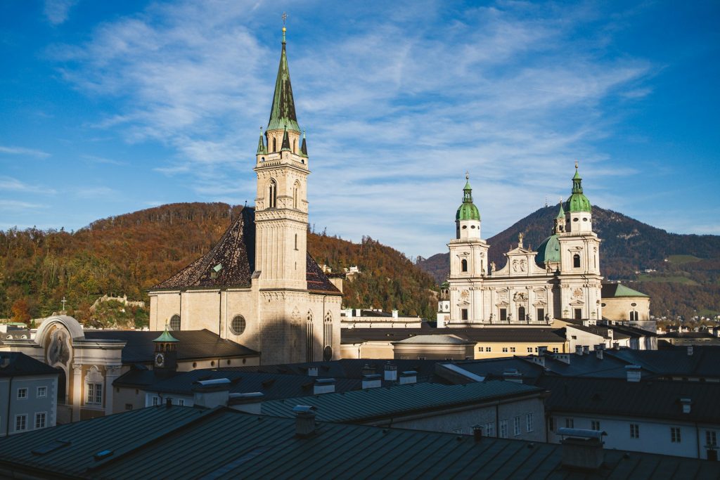 catedral salzburgo. Foto tirada de cima com uma construção grande com duas torres em concreto branco.