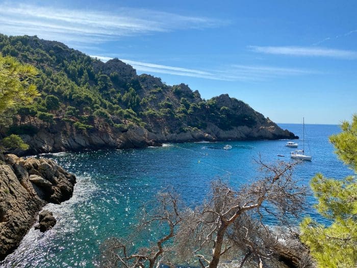 Marselha. mar azul com alguns barcos atracados e montanhas ao redor.