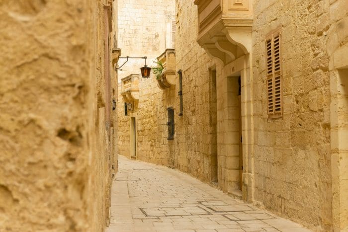 Mdina. rua estreita com casas de pedra nos dois lados.