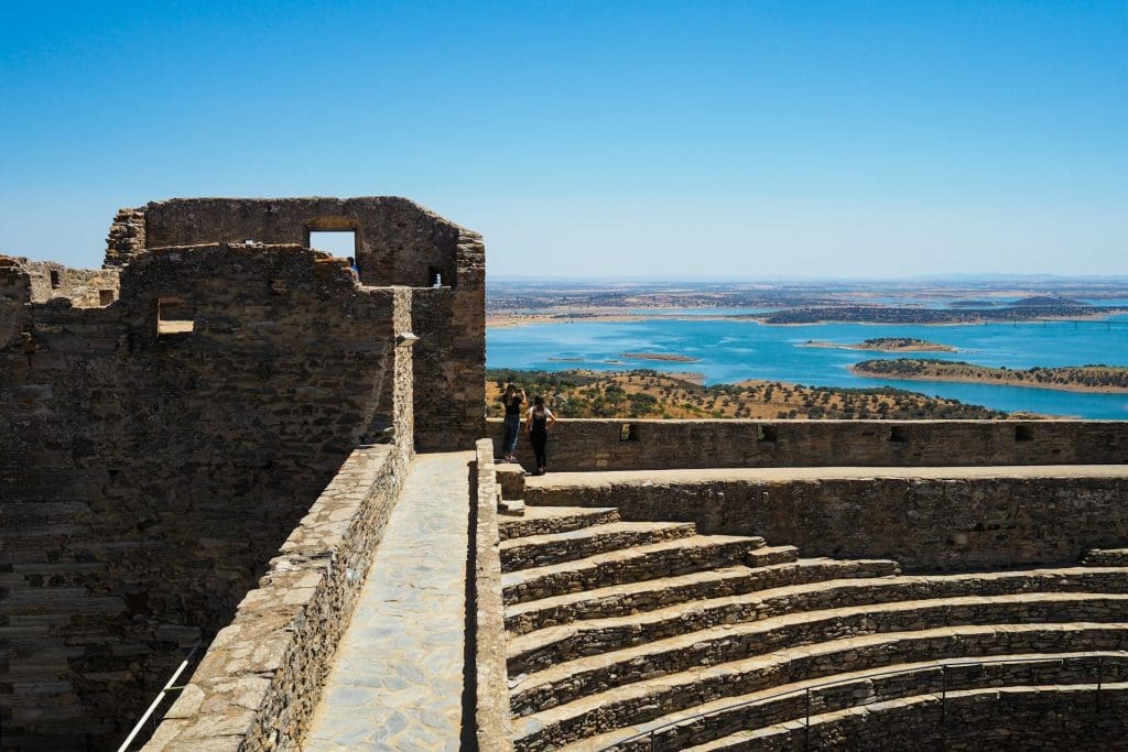 Monsaraz. foto tirada do alto de um edificio de pedra com a paisagem de agua e pequenas ilhas de terra.